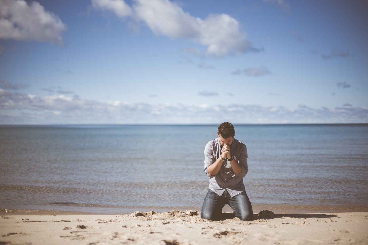 A person is praying on the beach.